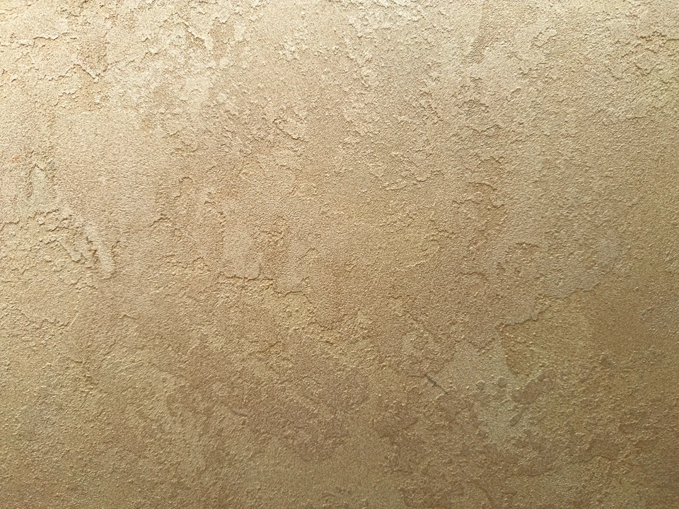 Mur en parement de pierre naturelle beige avec finition éclatée, assemblage en opus romain irrégulier créant un relief tridimensionnel