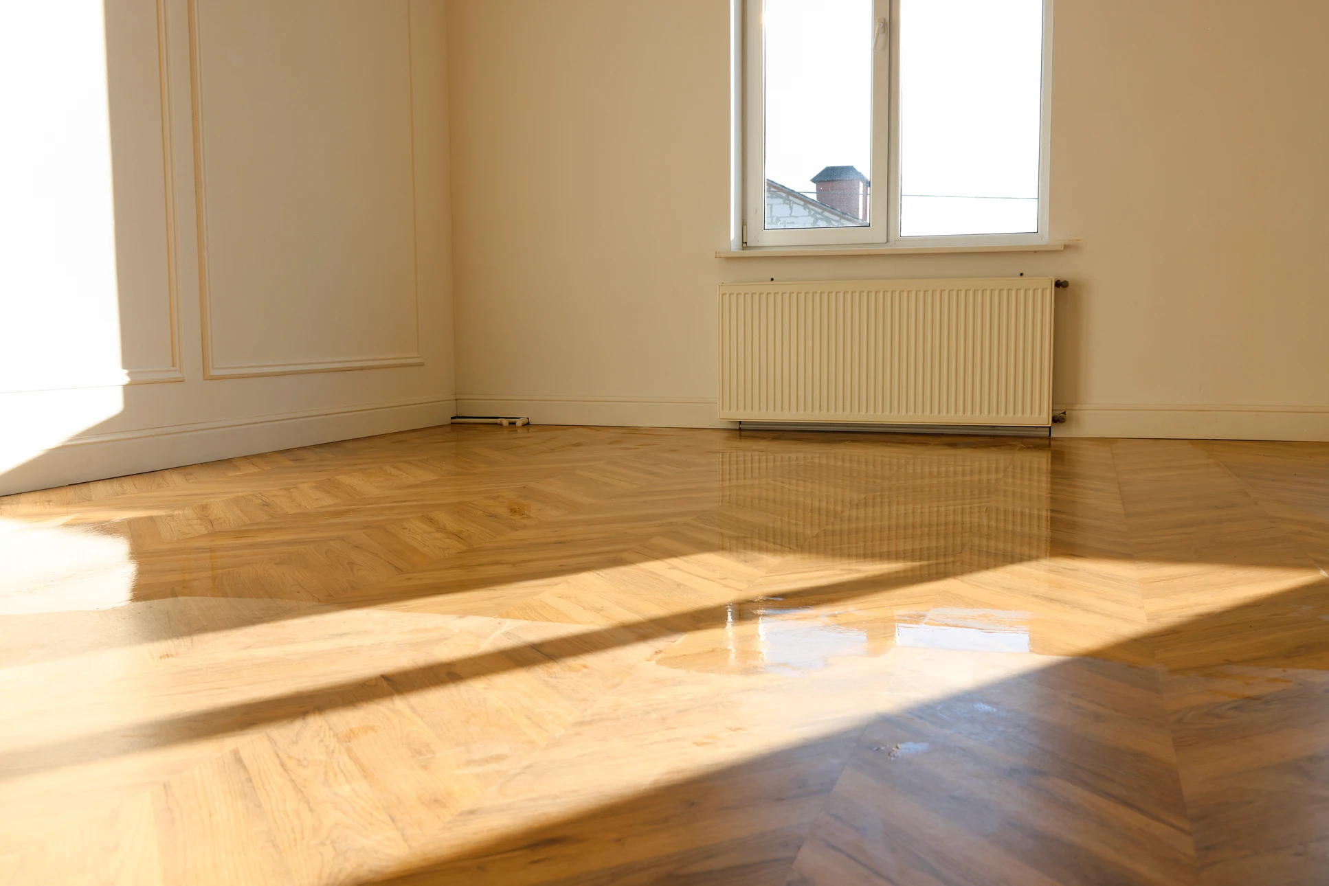 Parquet en bois naturel disposé en motif chevron, créant un sol élégant d'intérieur