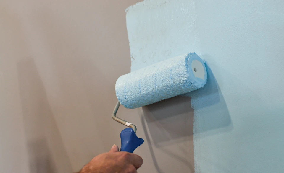 Scène d'intérieur en cours de rénovation avec mur partiellement peint en blanc